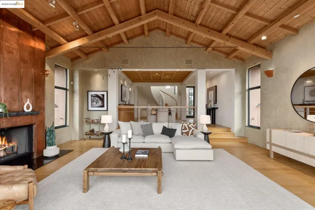 a kitchen with stainless steel appliances kitchen island granite countertop a stove a refrigerator a sink a dining table and chairs with wooden floor