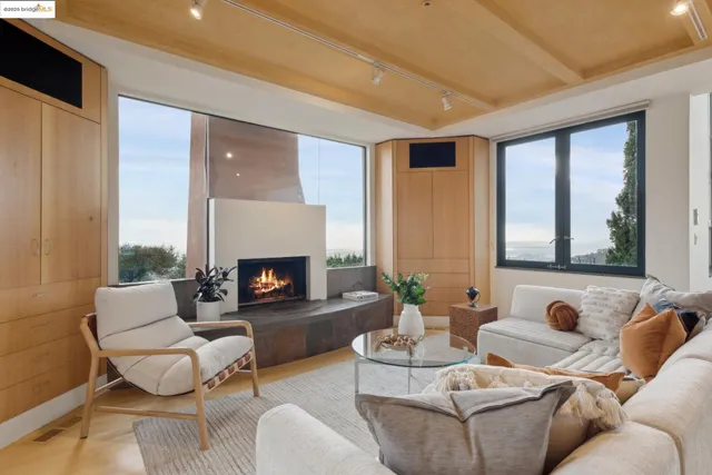 a living room with furniture a fireplace and a large window