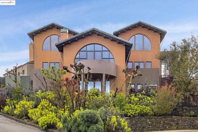 a front view of a house with a yard and plants