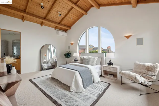 a spacious bedroom with a bed and glass window