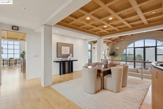 a dining room with wooden floor a chandelier a wooden table and chairs