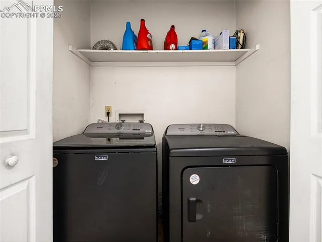 a utility room with dryer washer and shoe rack