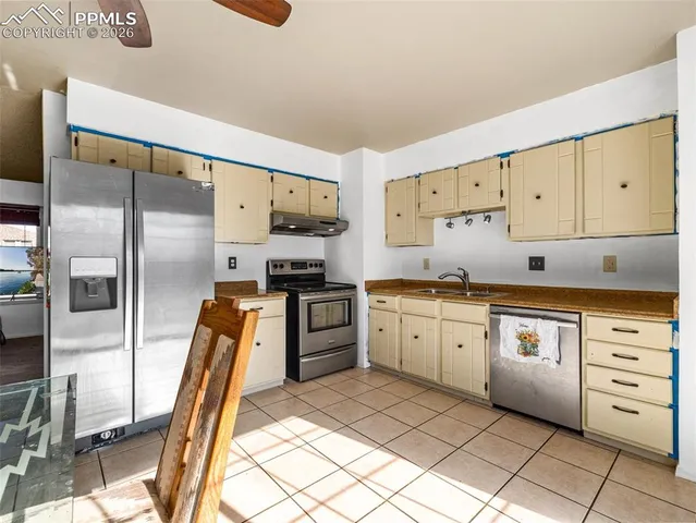 a kitchen with granite countertop cabinets stainless steel appliances and a sink
