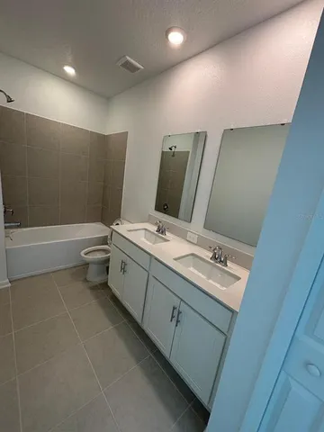 a bathroom with a double vanity sink toilet and shower