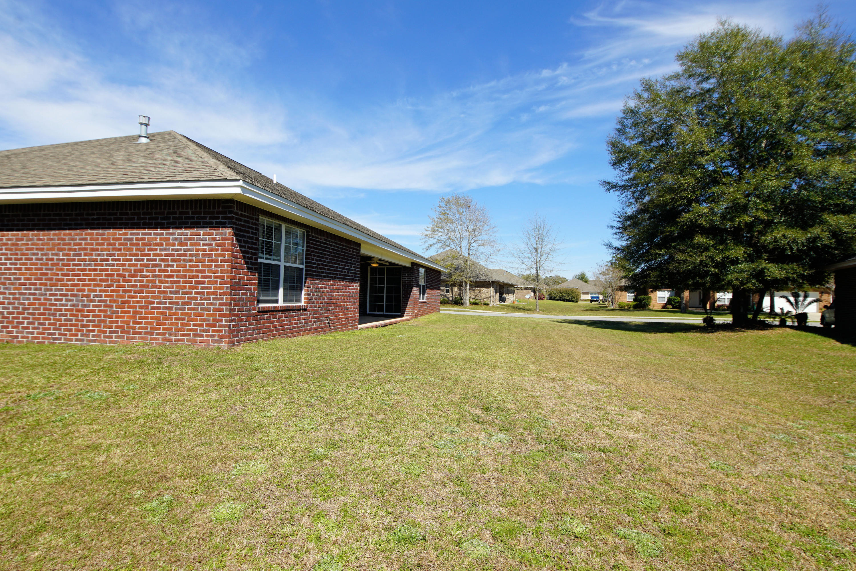 4613 Chanan Drive Crestview, FL 32539 - Photo 38 of 44 a backyard of a house with lots of green space