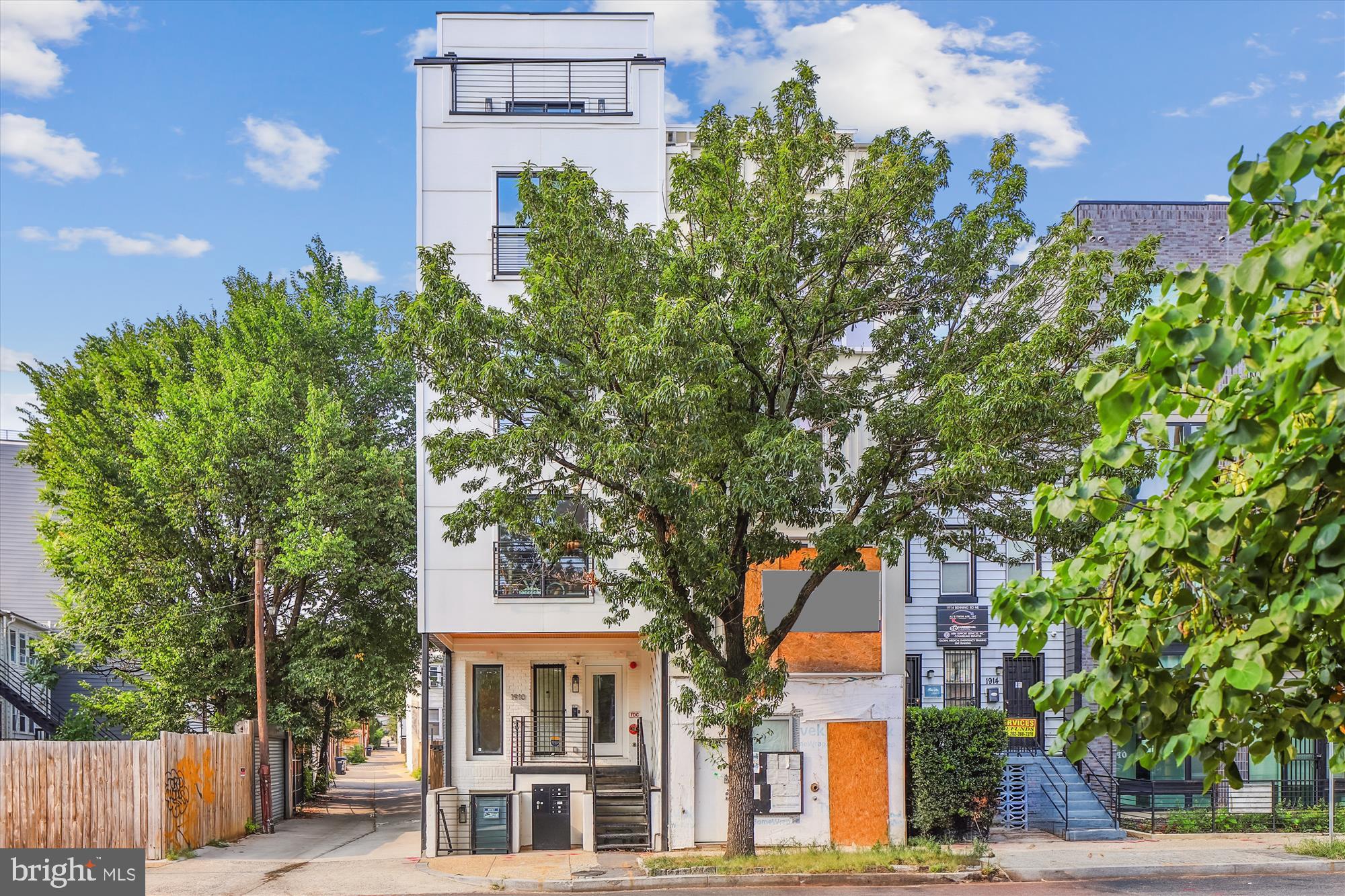 1910 Benning Road Northeast, Unit 2 Washington, DC 20002 - Photo 1 of 19 front view of a building with a tree
