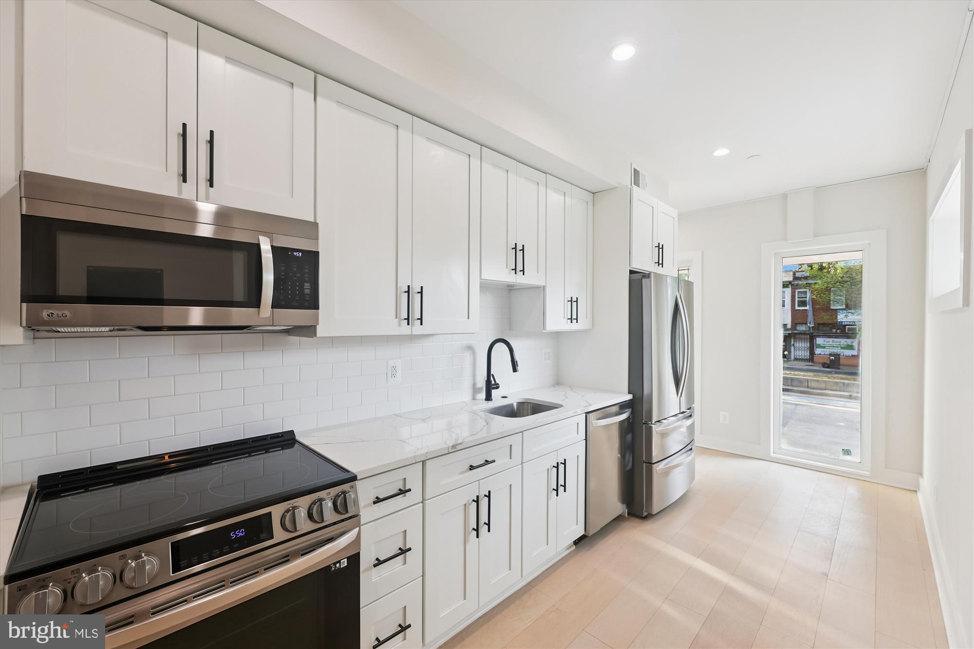 1910 Benning Road Northeast, Unit 2 Washington, DC 20002 - Photo 3 of 19 a kitchen with stainless steel appliances a stove a sink and a refrigerator