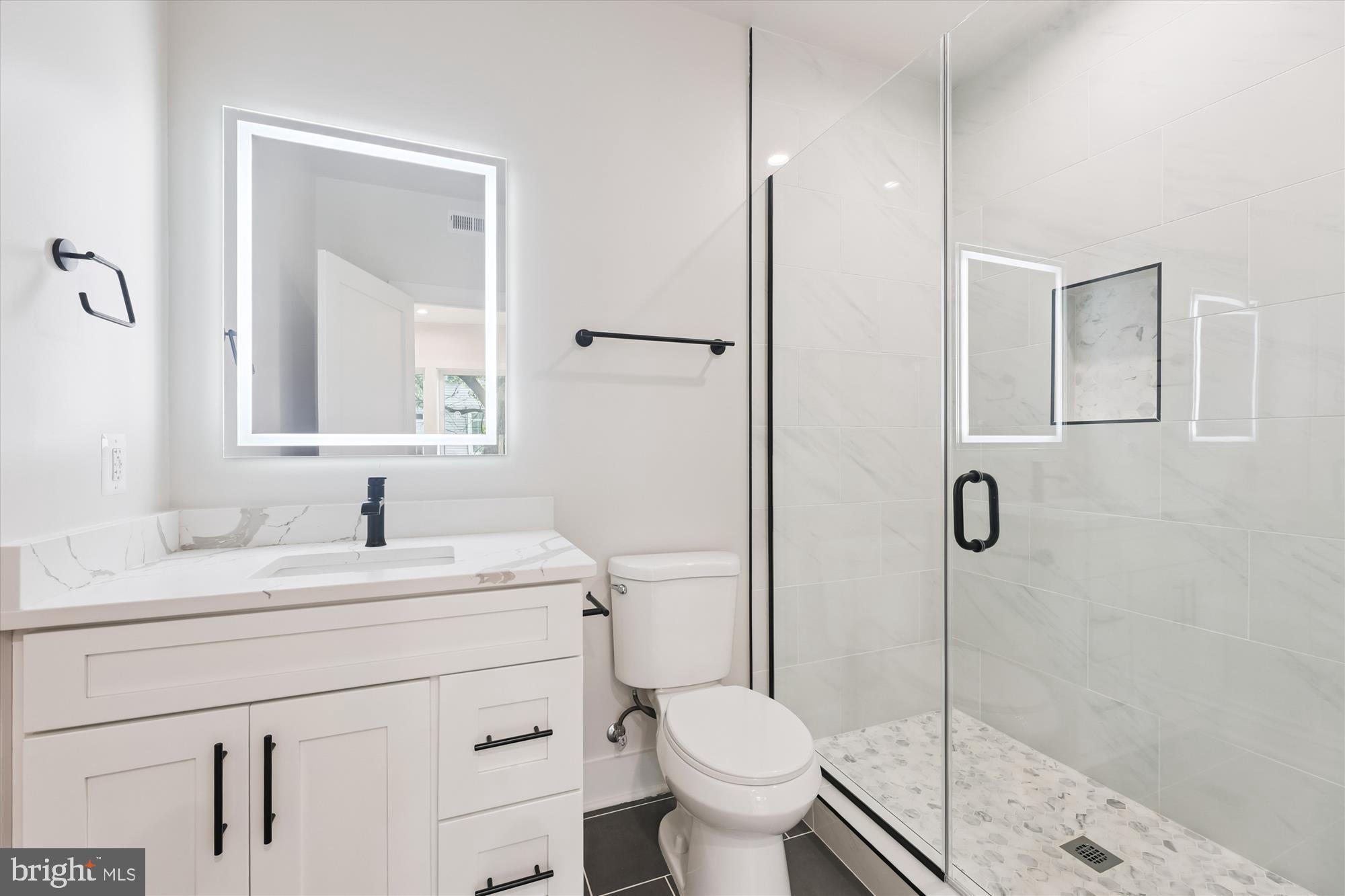 1910 Benning Road Northeast, Unit 2 Washington, DC 20002 - Photo 10 of 19 a bathroom with a sink toilet vanity and shower
