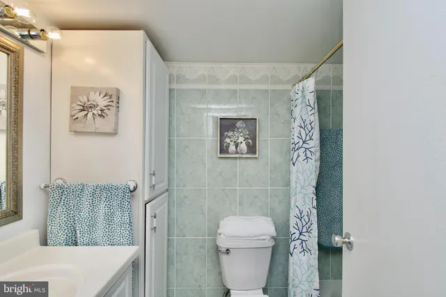 a bathroom with a sink mirror vanity and toilet
