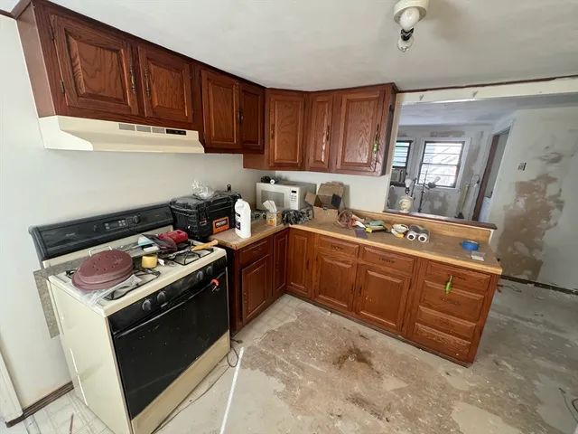 a kitchen with stainless steel appliances granite countertop a stove a sink dishwasher and cabinets with wooden floor