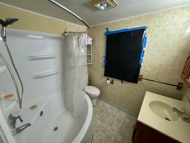 a bathroom with a tub sink and mirror