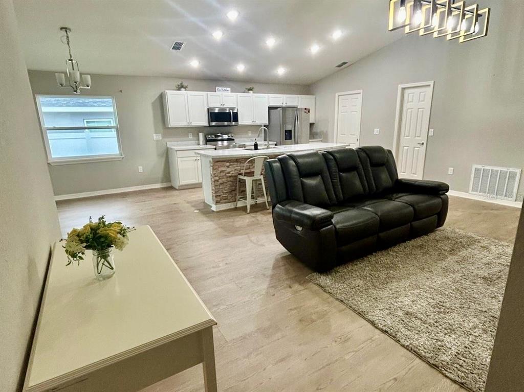 4098 Ruby Run Haines City, FL 33844 - Photo 11 of 34 a living room with stainless steel appliances kitchen island granite countertop furniture and a view of kitchen appliances