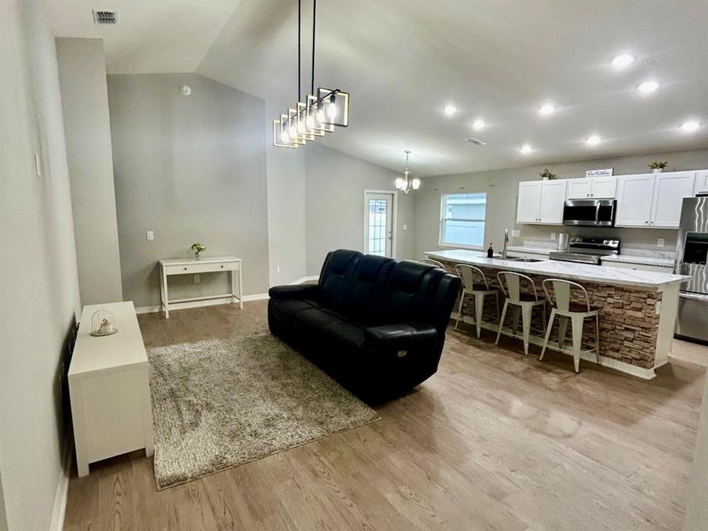 4098 Ruby Run Haines City, FL 33844 - Photo 12 of 34 a living room with furniture a two couches and kitchen view