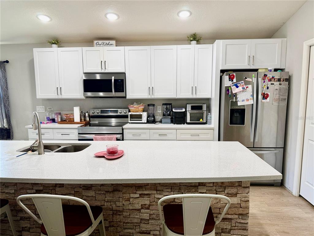 4098 Ruby Run Haines City, FL 33844 - Photo 16 of 34 a kitchen with kitchen island granite countertop a sink cabinets and refrigerator