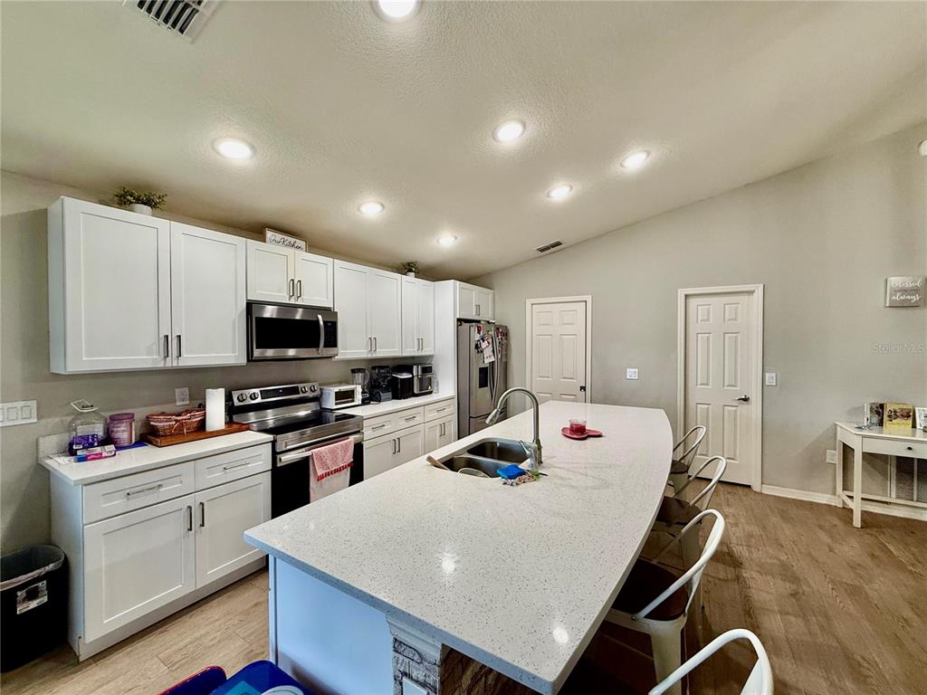 4098 Ruby Run Haines City, FL 33844 - Photo 17 of 34 a large white kitchen with sink and white appliances