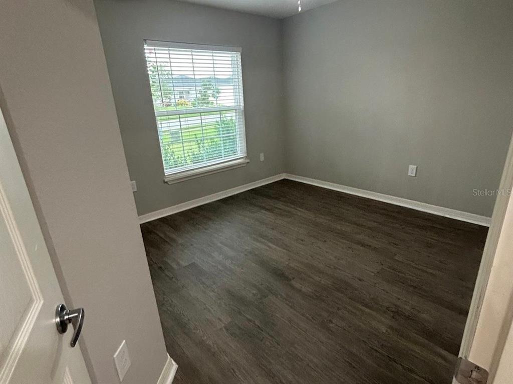 4098 Ruby Run Haines City, FL 33844 - Photo 21 of 34 an empty room with wooden floor and windows