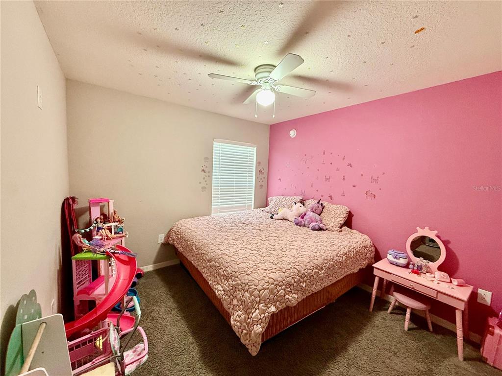 4098 Ruby Run Haines City, FL 33844 - Photo 25 of 34 a bedroom with a bed and a chandelier