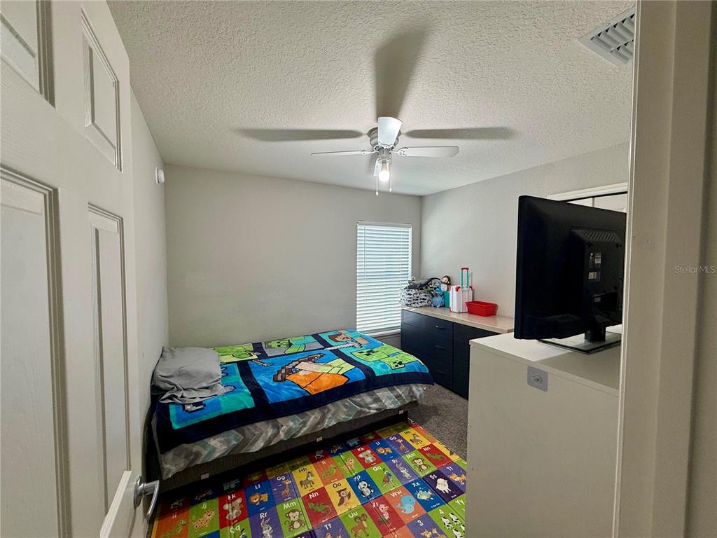 4098 Ruby Run Haines City, FL 33844 - Photo 27 of 34 a kids room that has a bed and a table in it