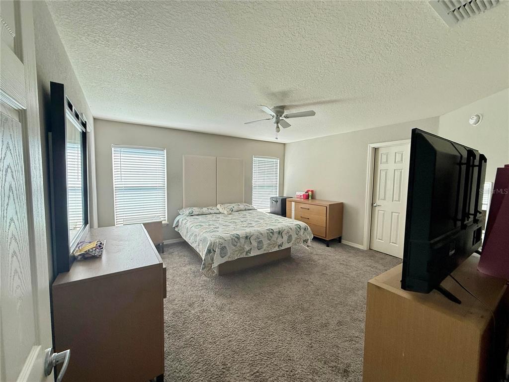 4098 Ruby Run Haines City, FL 33844 - Photo 30 of 34 a bedroom with a bed and a flat screen television