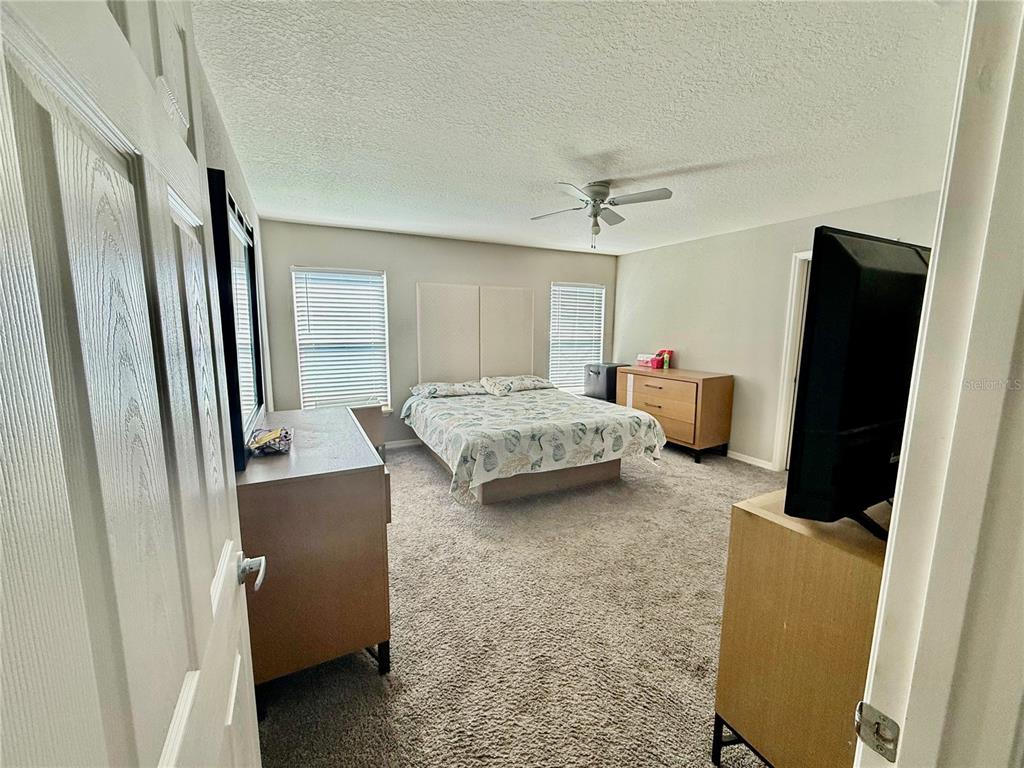 4098 Ruby Run Haines City, FL 33844 - Photo 31 of 34 a bedroom with a bed and a refrigerator