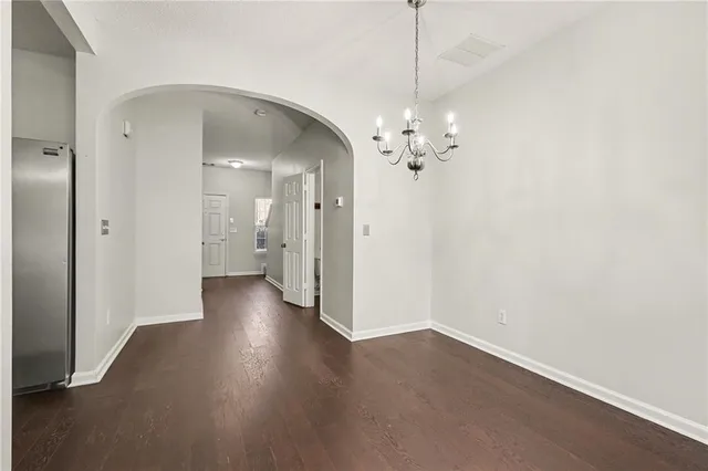 a view of a hallway with wooden floor and a chandelier