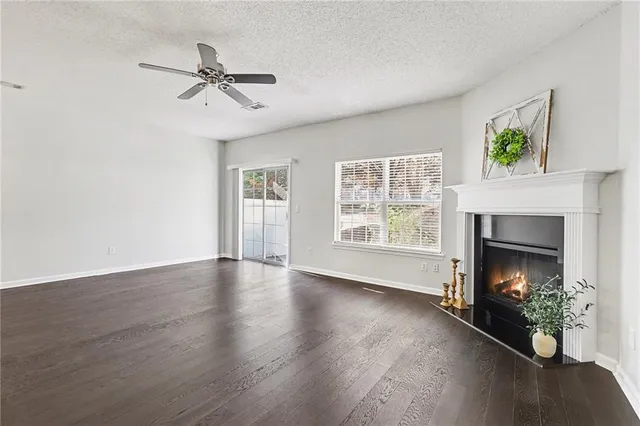 a view of an empty room with a fireplace and a window