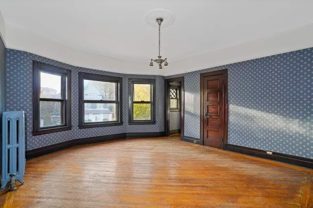 a view of an empty room with glass door and windows