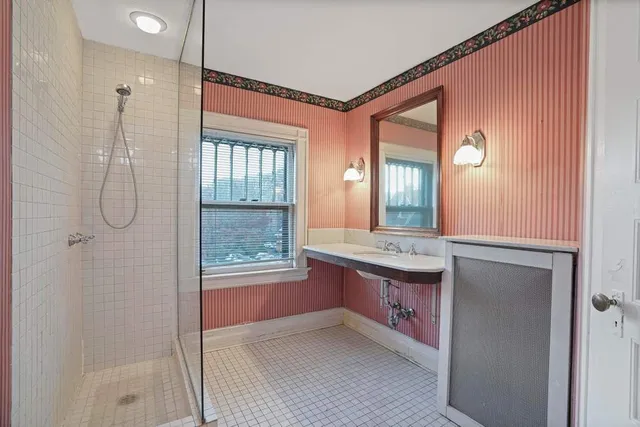 a bathroom with a granite countertop sink a mirror and a shower