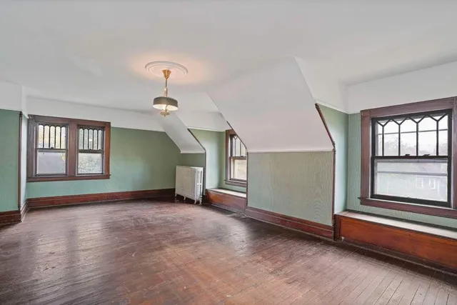 an empty room with windows and cabinet