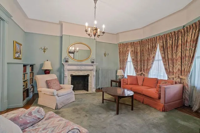 a living room with furniture a fireplace and a chandelier