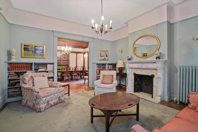 a living room with furniture a fireplace and a chandelier