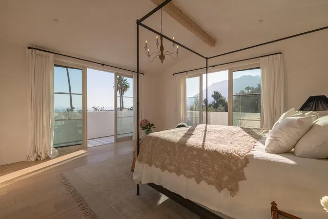 a bed sitting in a bedroom next to a large window