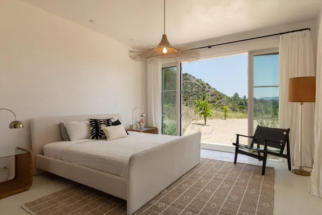 a bedroom with a bed and a large window