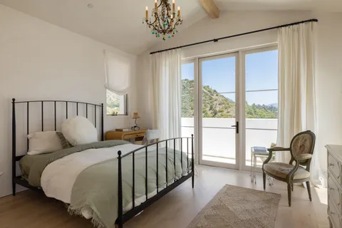 a bedroom with a bed and a balcony view