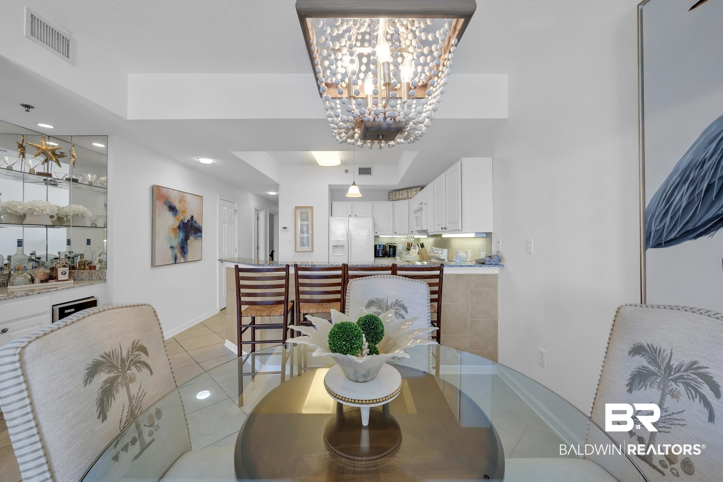 27282 Canal Road, Unit 104 Orange Beach, AL 36561 - Photo 29 of 79 Dining area featuring light tile patterned flooring, a chandelier, recessed lighting, and a tray ceiling