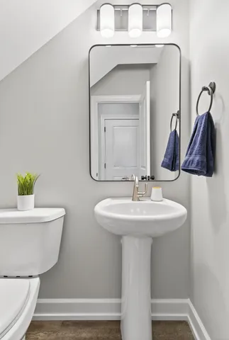 a bathroom with a toilet a sink and a mirror