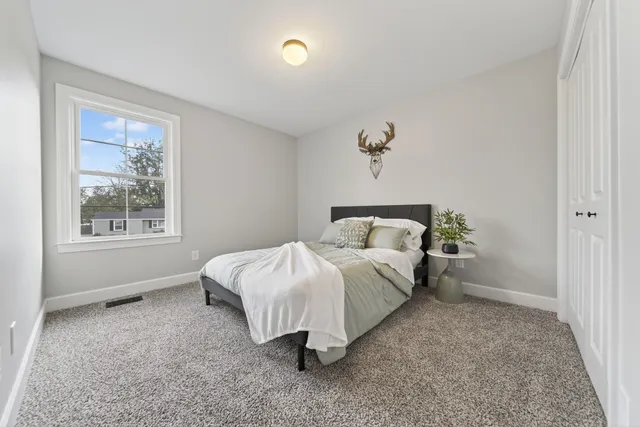 a bathroom with a double vanity sink a toilet a mirror and shower