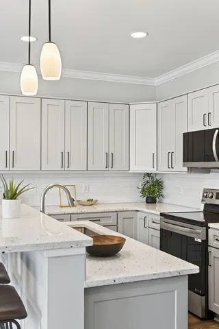 a kitchen with granite countertop a sink a stove and cabinets