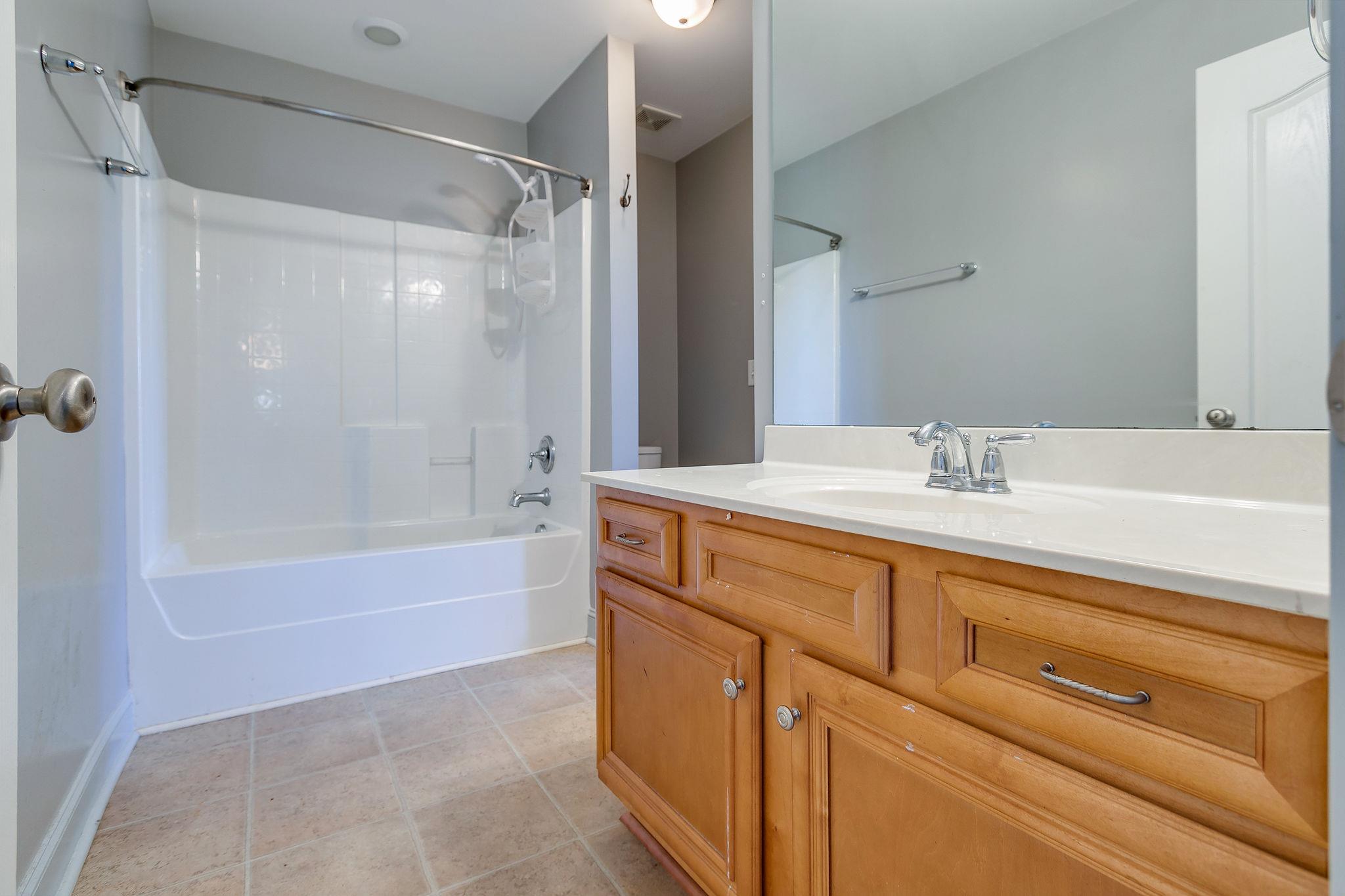 2029 Lincoln Road Spring Hill, TN 37174 - Photo 23 of 30 a bathroom with a granite countertop sink a mirror shower and a bathtub