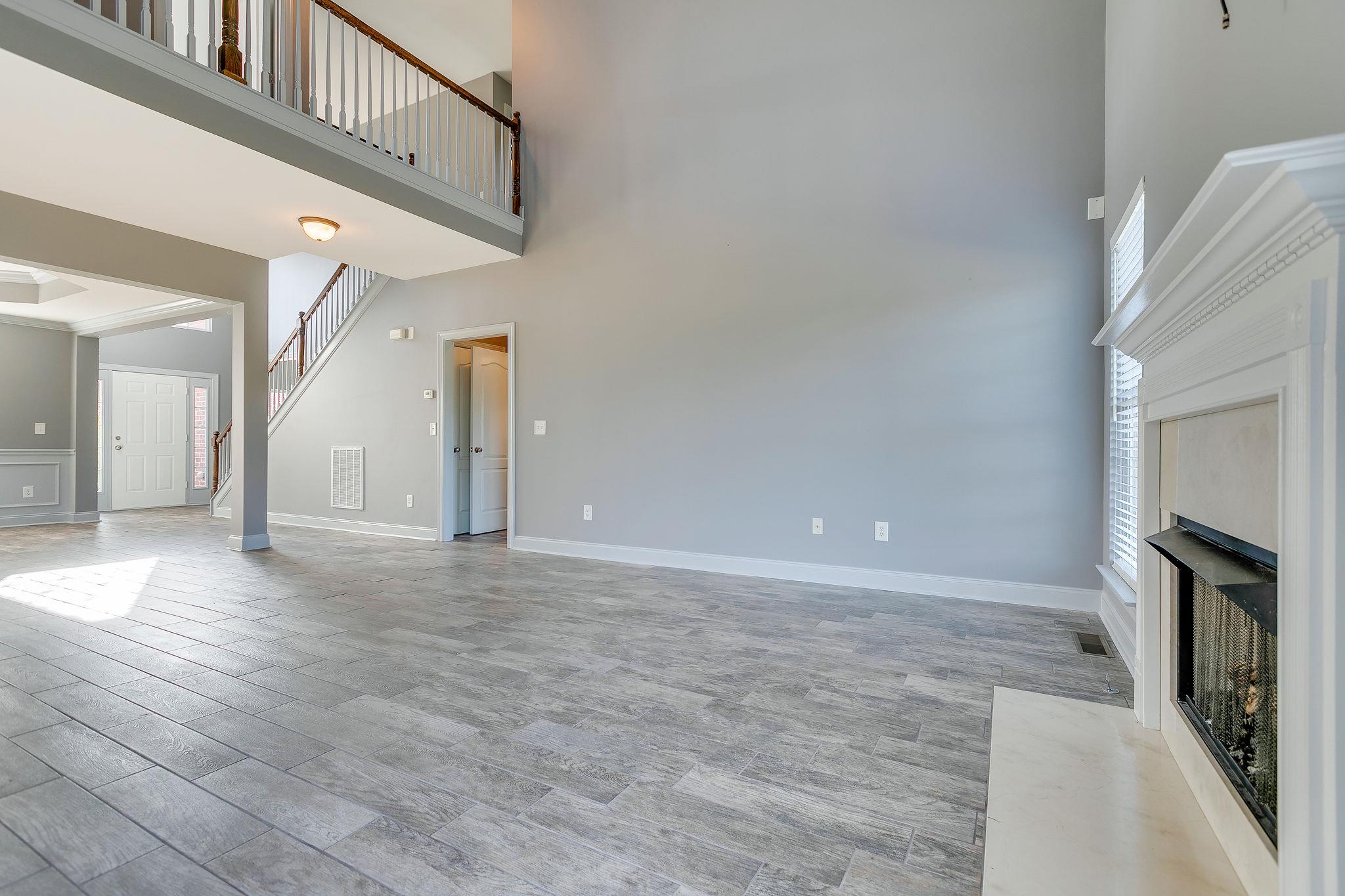 2029 Lincoln Road Spring Hill, TN 37174 - Photo 8 of 30 a view of a hallway with entryway wooden floor and a fireplace