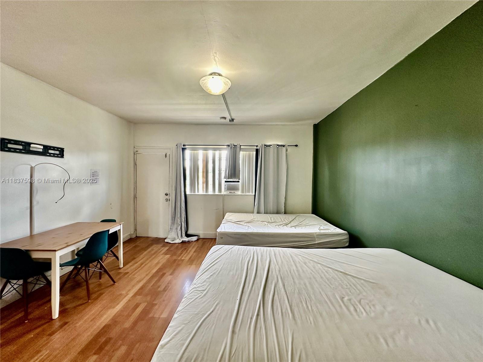 26 Diplomat Parkway, Unit 2368 Hallandale Beach, FL 33009 - Photo 3 of 12 a bedroom with a bed and a table in it