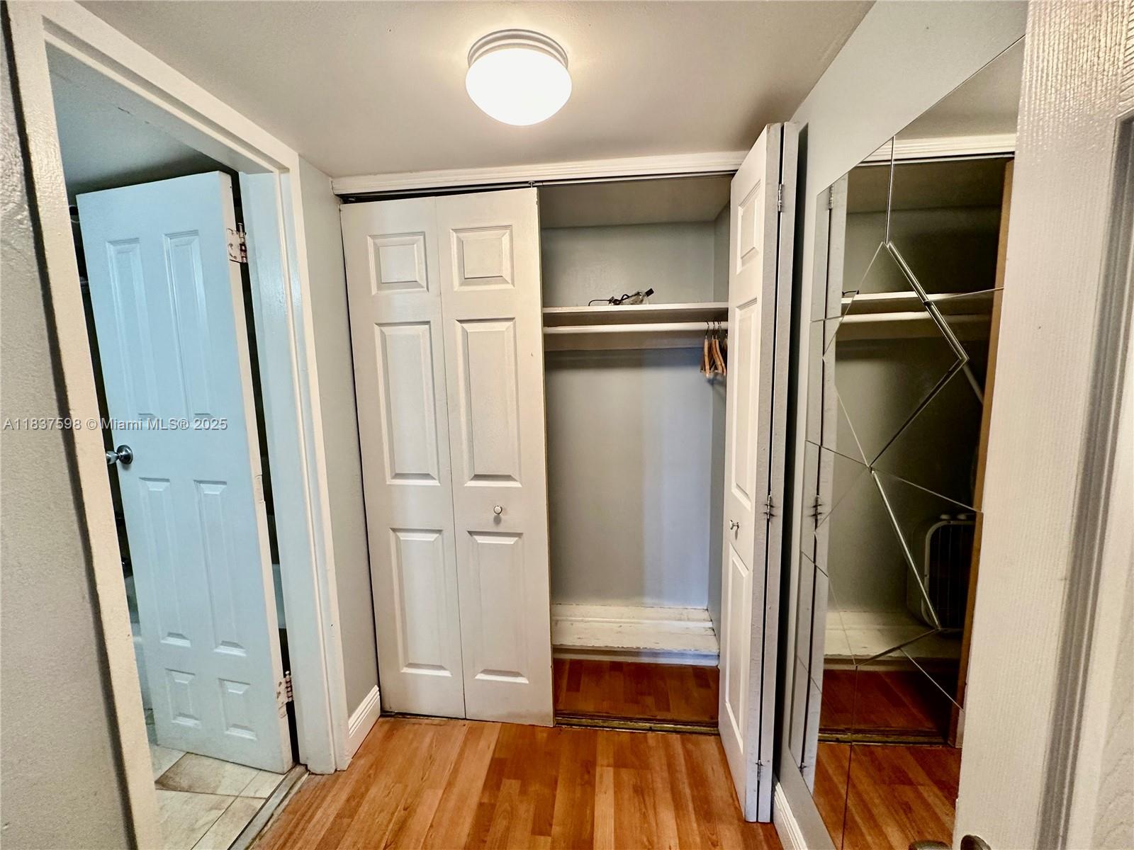26 Diplomat Parkway, Unit 2368 Hallandale Beach, FL 33009 - Photo 4 of 12 a view of walk in closet with wooden floor and tub