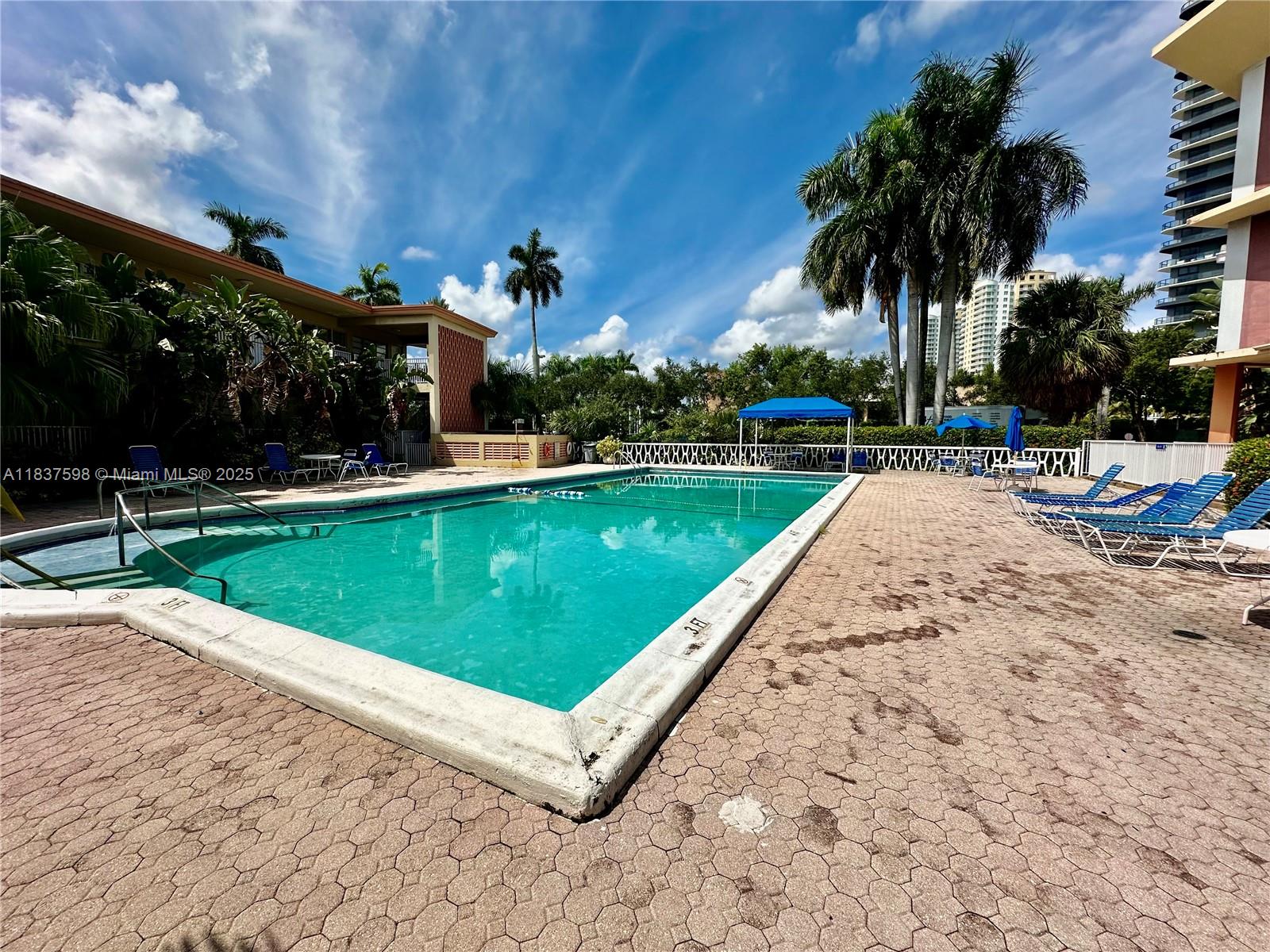 26 Diplomat Parkway, Unit 2368 Hallandale Beach, FL 33009 - Photo 10 of 12 a view of a swimming pool and lounge chairs