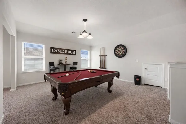 a room with pool table and windows