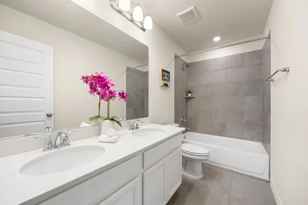 a bathroom with a granite countertop sink a toilet and shower