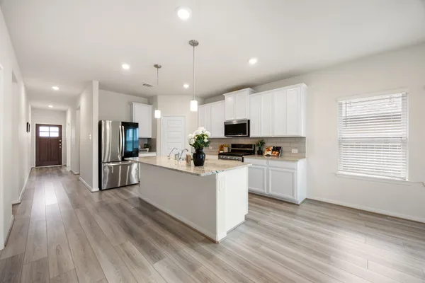 a kitchen with white cabinets and stainless steel appliances