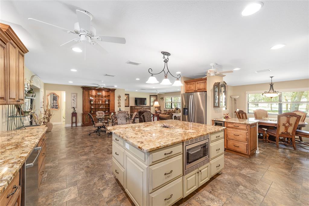 3200 Northeast 97th Street Road Anthony, FL 32617 - Photo 22 of 75 a large kitchen with kitchen island a stove a dining table and chairs