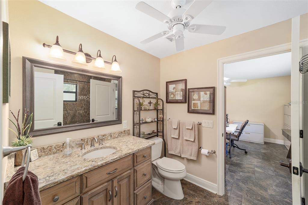 3200 Northeast 97th Street Road Anthony, FL 32617 - Photo 34 of 75 a bathroom with a granite countertop toilet sink and mirror