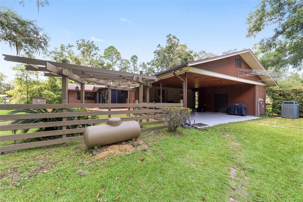 3200 Northeast 97th Street Road Anthony, FL 32617 - Photo 60 of 75 a view of a backyard with table and chairs potted plants and large tree