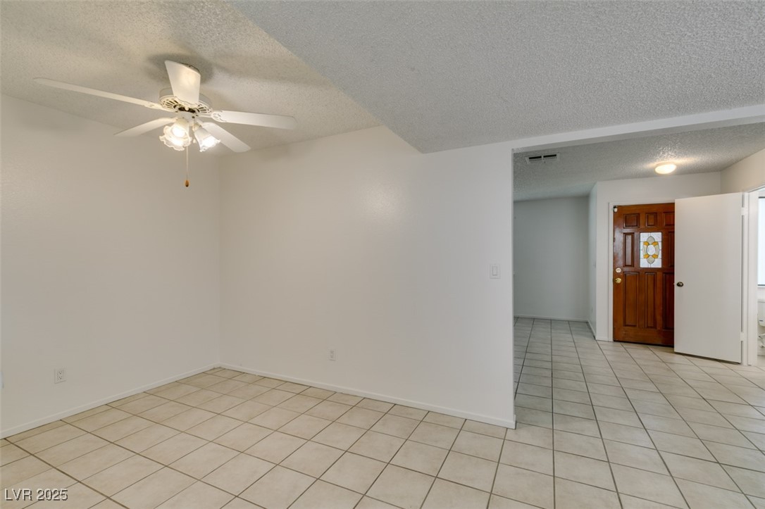 2681 Ruthe Duarte Avenue Las Vegas, NV 89121 - Photo 17 of 43 Unfurnished room featuring visible vents, a textured ceiling, a ceiling fan, and light tile patterned flooring